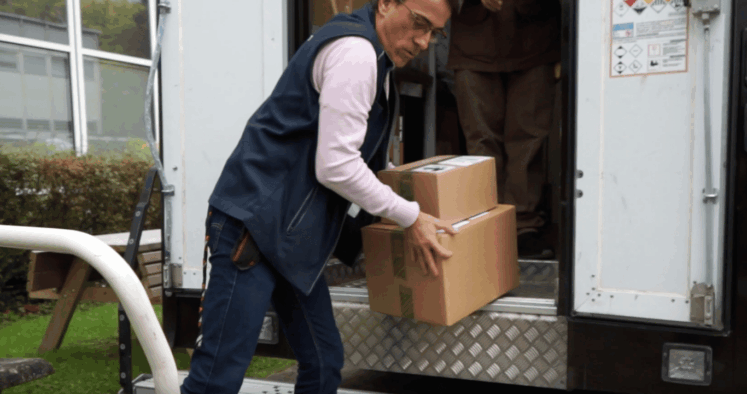 Homme sortant des cartons d'un camion