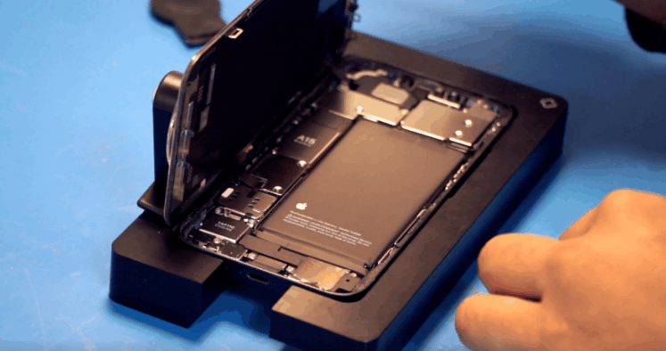 Photo en gros plan d’un smartphone ouvert sur un support de réparation, montrant ses composants internes