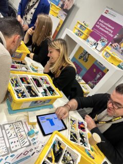 Photo d'adultes autours d'une table faisant des Lego