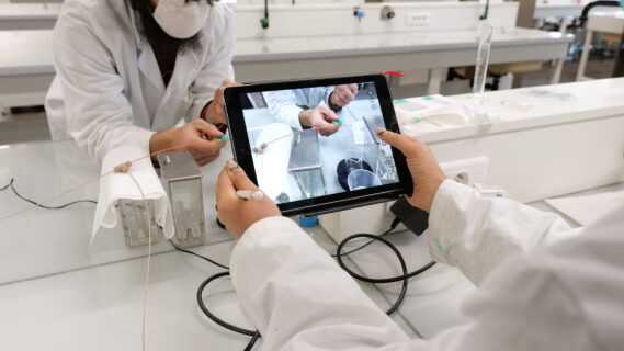 personne se servant d'un iPad pour prendre en photo une expérience dans un laboratoire
