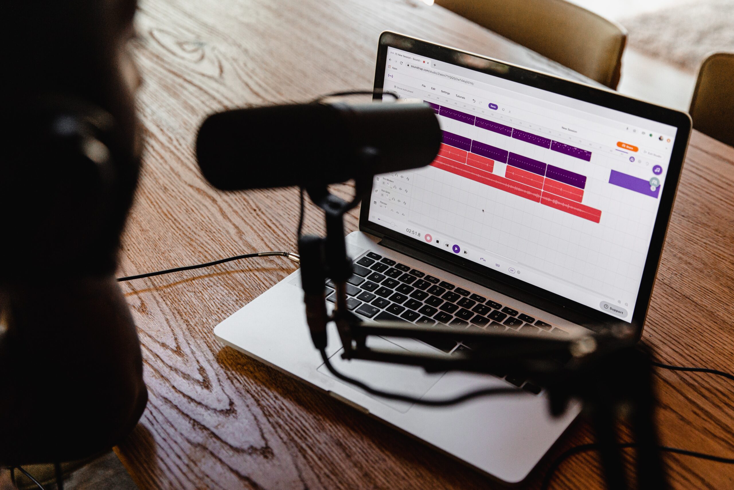 personne parlant dans un micro avec son MacBook en fond