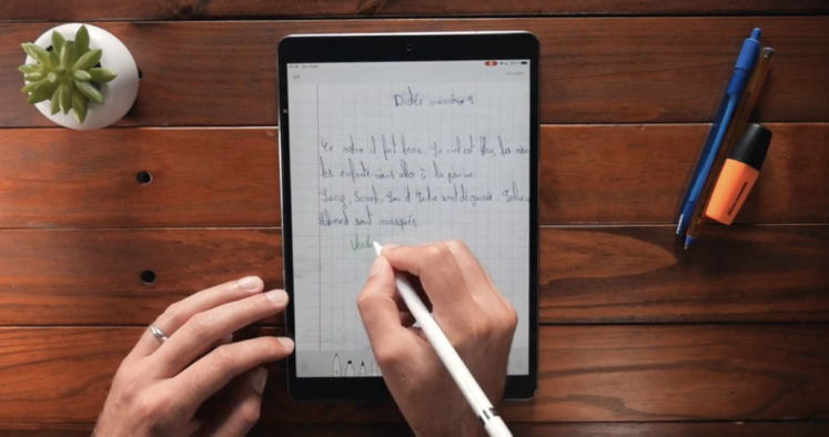 main écrivant avec un stylet sur un iPad
