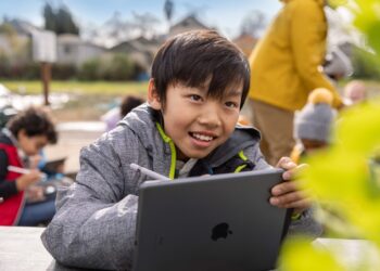 enfant dehors utilisant son stylet pour écrire sur son iPad
